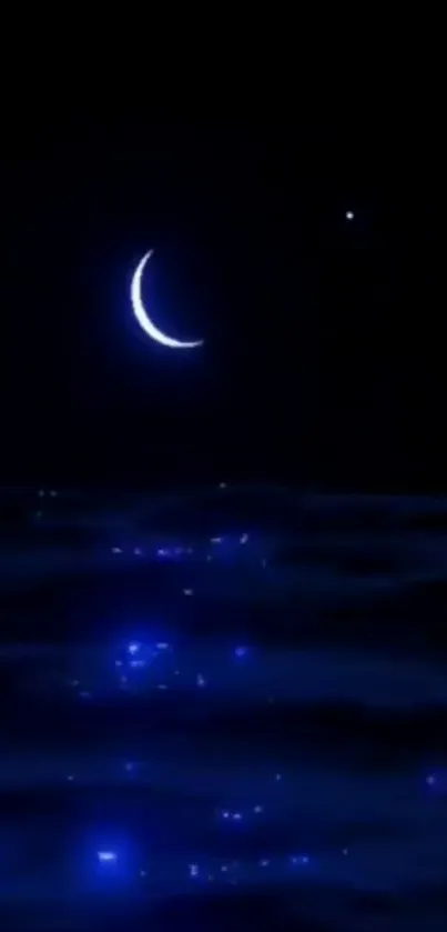 Serene crescent moon over blue ocean at night.