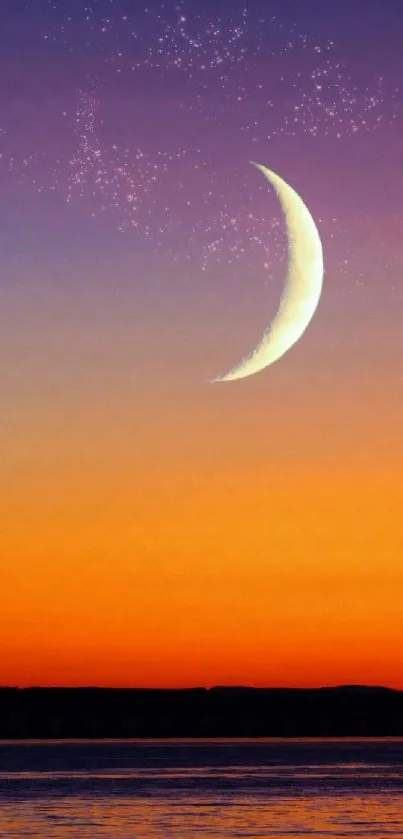 Crescent moon over vibrant orange sunset on ocean horizon.