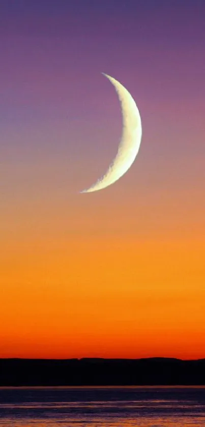 Crescent moon over a vibrant sunset sky.