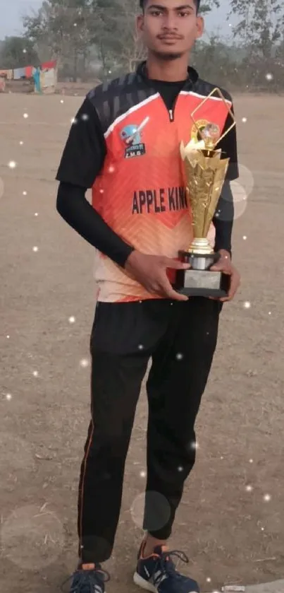 Player holding a trophy on a cricket field.