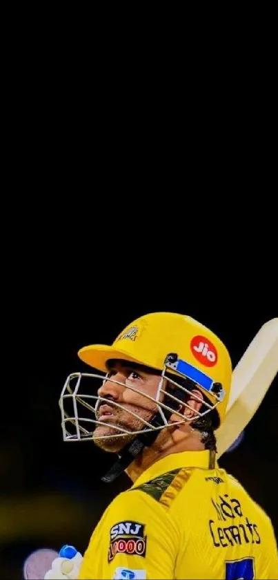 Cricketer wearing a yellow jersey and helmet holding a bat.