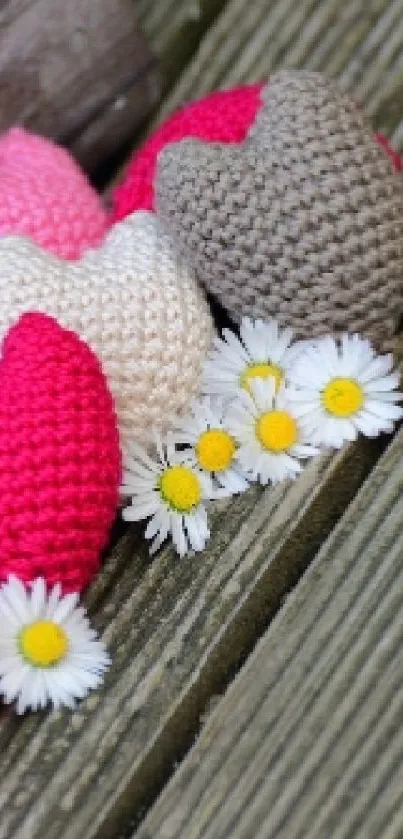 Crochet hearts and daisies on wooden background wallpaper.