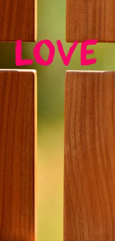 Wooden cross with 'LOVE' in pink text on mobile wallpaper.