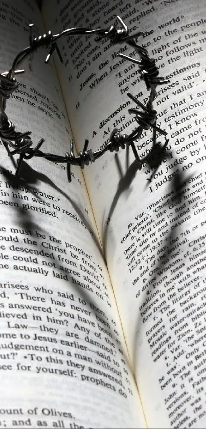 Crown of thorns casting heart-shaped shadow on an open book page wallpaper.