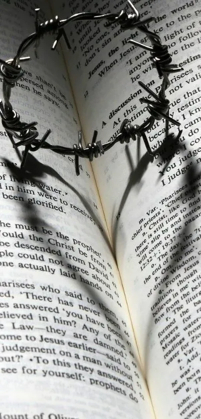 Barbed wire crown casting heart shadow on Bible pages.