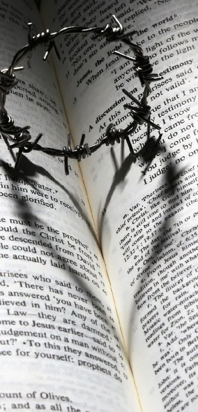 Crown of thorns shadow forming a heart on an open book in a serene setting.