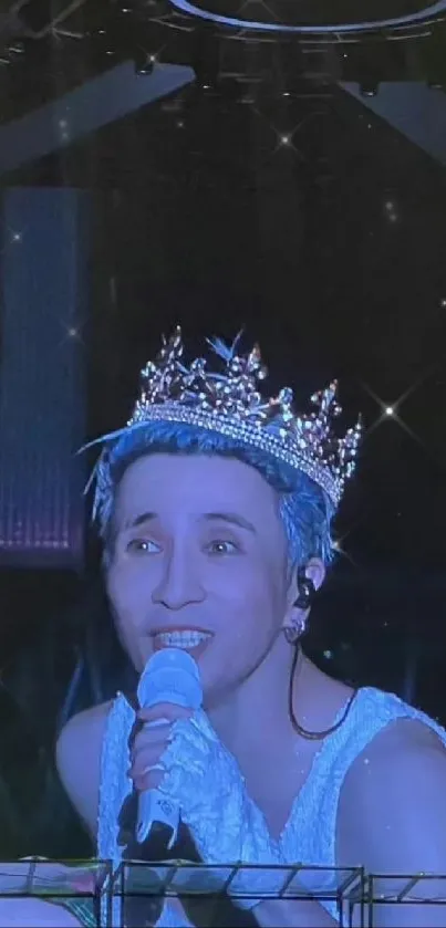 Singer on a dim stage wearing a sparkling crown with a microphone.