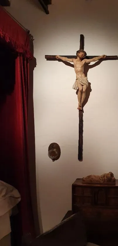 Mobile wallpaper of a crucifix on a wall in a dimly lit room.