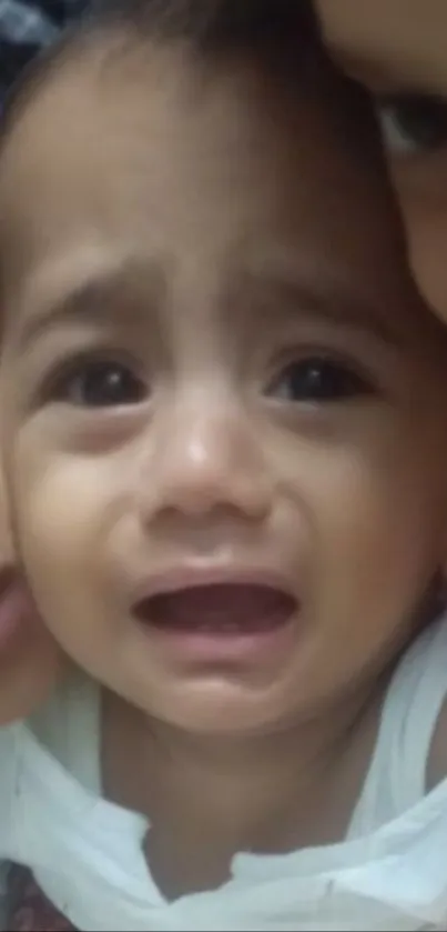 Crying baby close-up with tearful eyes.