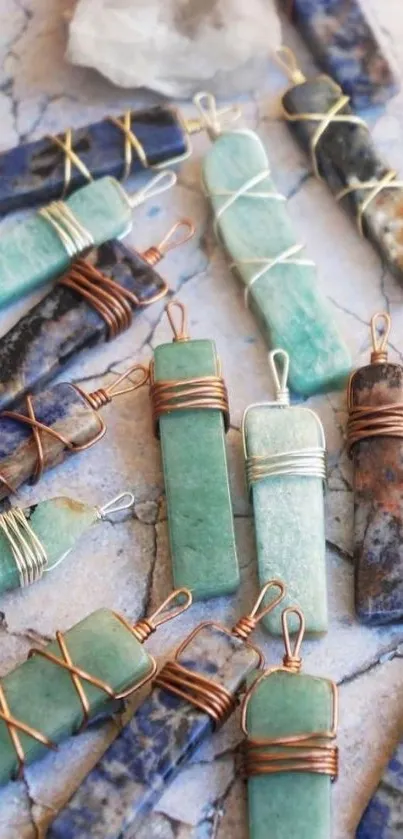 Crystal gemstone pendants wrapped in wire on a textured surface.