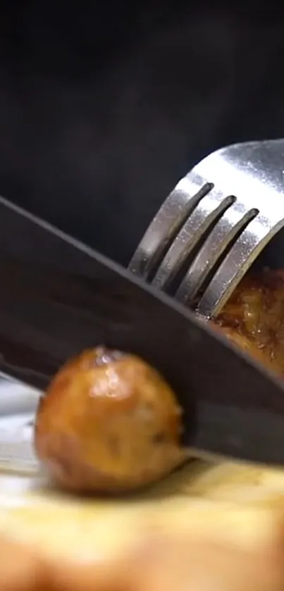 Close-up of knife and fork slicing a piece of brown meat on a plate.