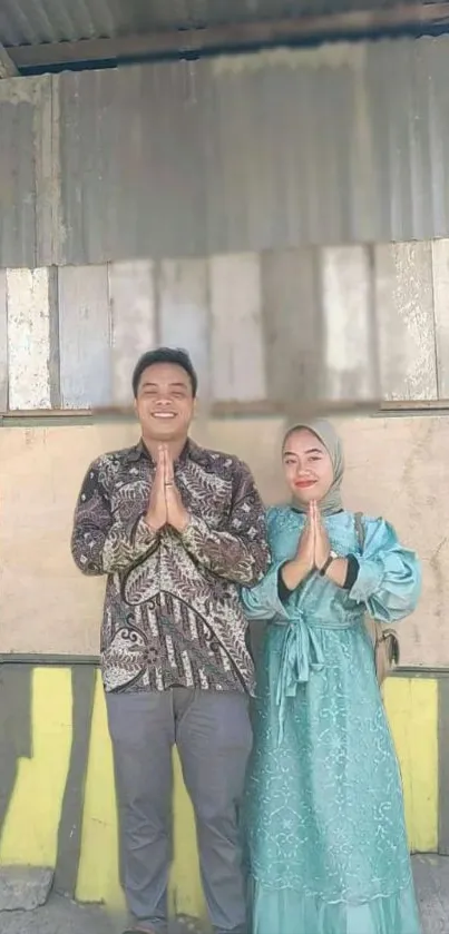 Man and woman in traditional attire greeting in urban setting.