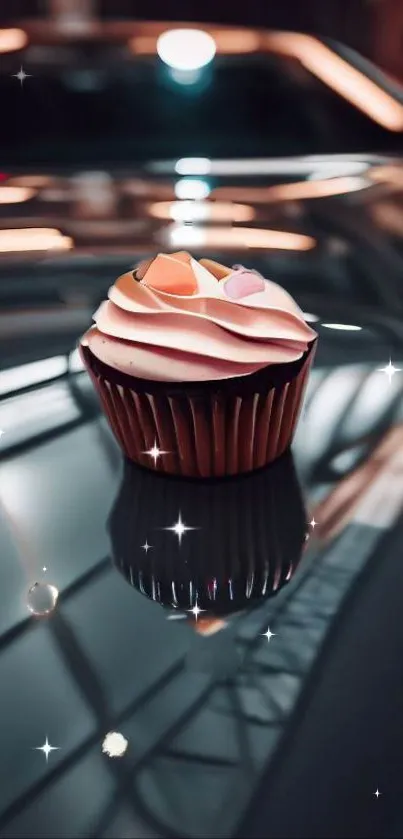 Cupcake on a car hood with sparkling lights and reflections.