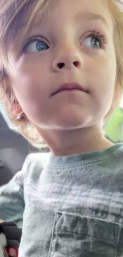 Child gazing with curiosity in soft light.