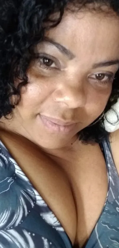 Close-up portrait of a smiling woman with curly hair.