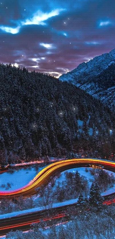 Curved road with light trails in snow-covered mountains at night.