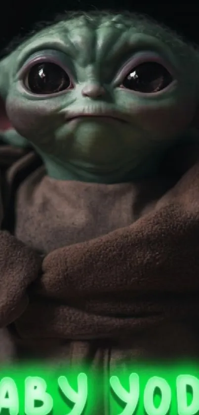 Cute green creature in a brown cloak with text 'Baby Yoda' glowing in green.