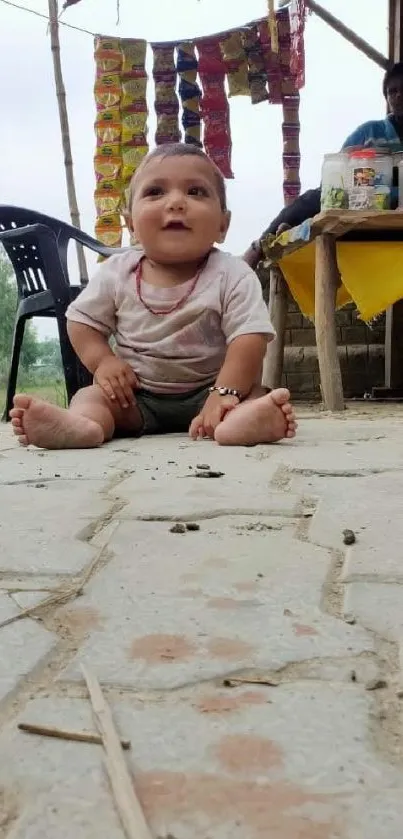 Baby sitting on stone pavement in rustic rural market scene.