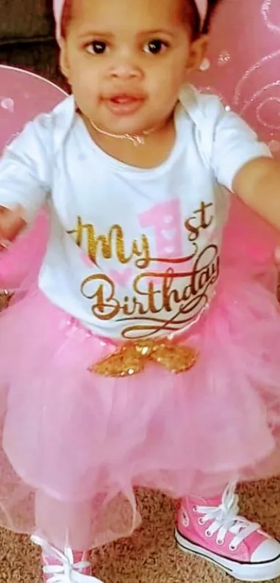 Adorable baby with pink tutu and wings celebrating birthday.