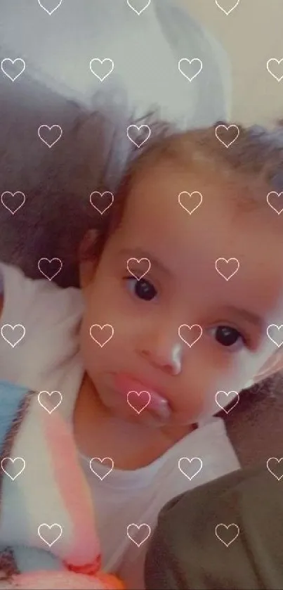 Cute baby with heart overlay wallpaper.