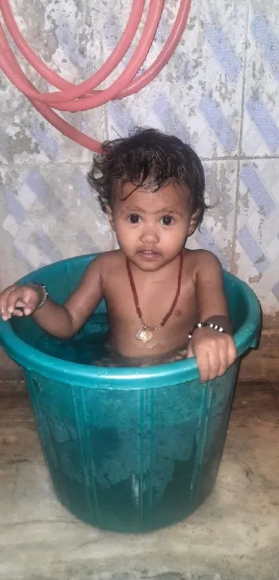 Cute baby sitting in water tub, smiling adorably.