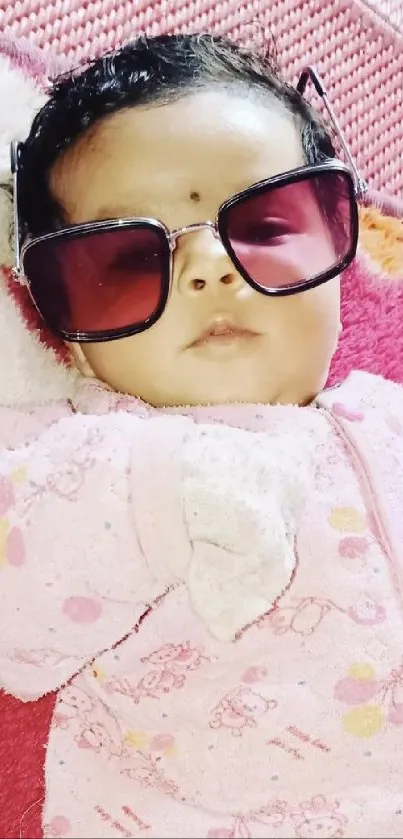 Baby with sunglasses on a colorful playmat.