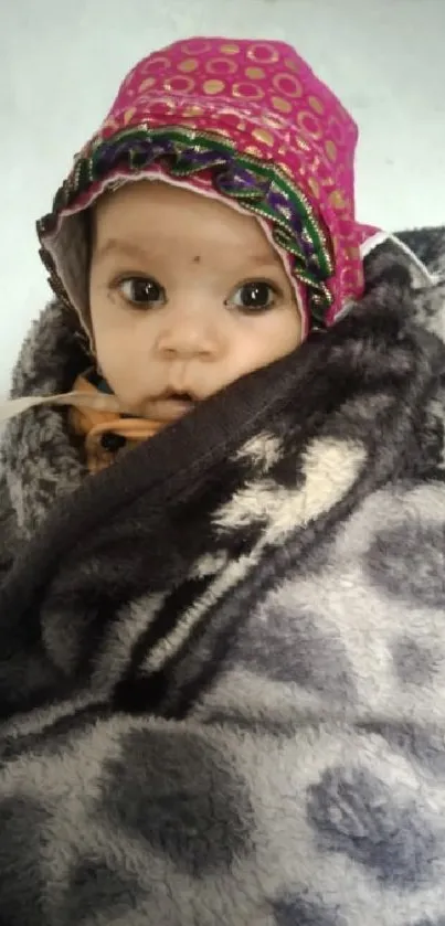 Adorable baby wrapped in a warm gray blanket, with a cute hat.