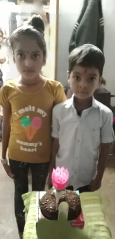 Kids celebrating birthday with cake indoors.