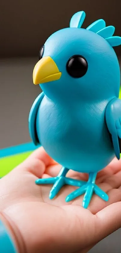 Toy blue bird with a yellow beak placed on a hand.