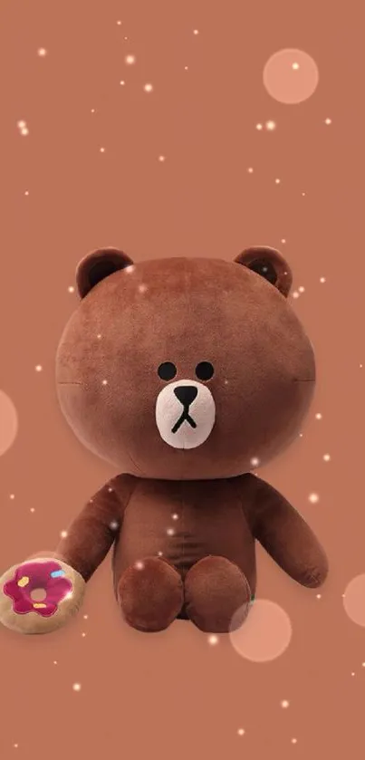 Adorable plush brown bear holding a donut on a copper background.