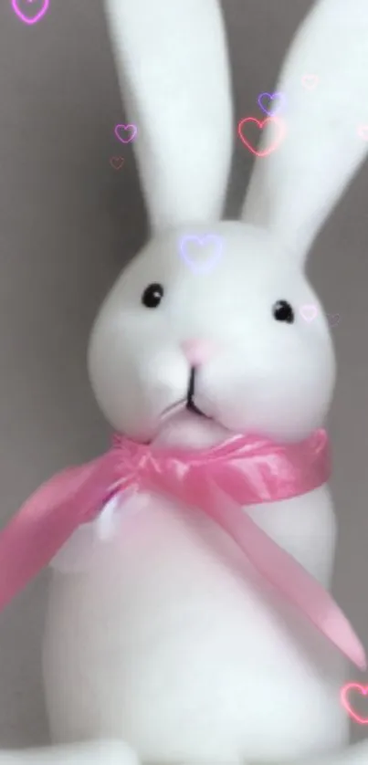 Cute white bunny with a pink ribbon surrounded by heart shapes.