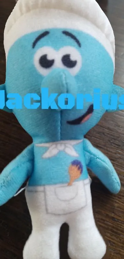 Plush cartoon toy with blue color on wooden surface.