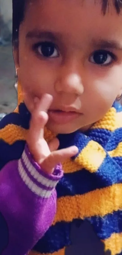 Cute child with a purple and yellow striped sweater.