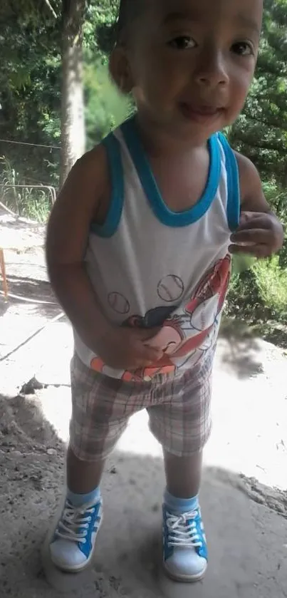 Adorable child in a forested area wearing a colorful outfit and blue sneakers.