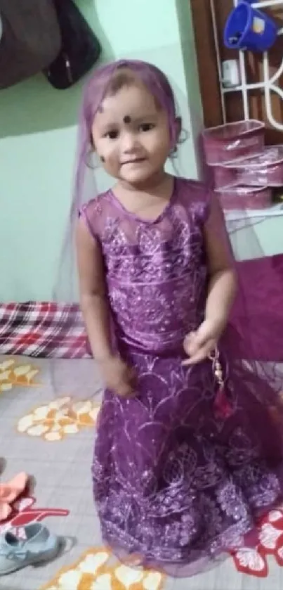 Adorable child in purple dress on a bed.