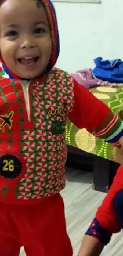 Smiling child in vibrant red outfit indoors.