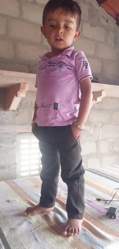 Child stands confidently on table in rustic room.