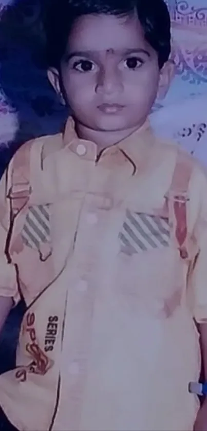 Adorable child in yellow shirt with a colorful background.