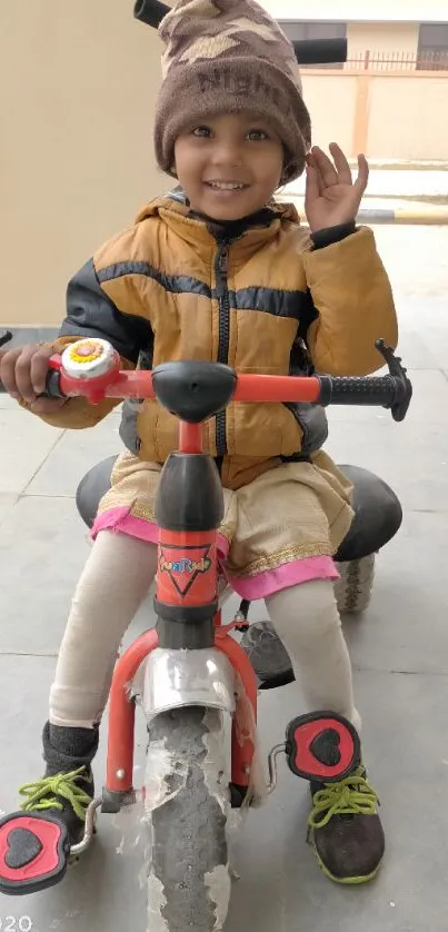 Smiling child rides a toy bike outdoors.