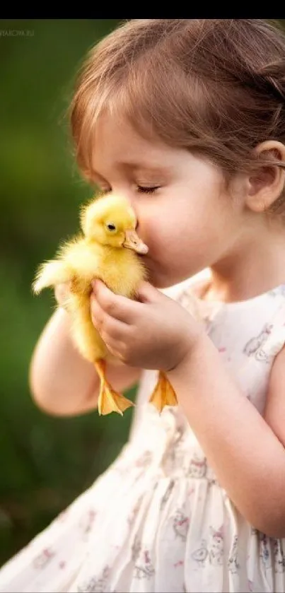 Child holding a yellow duckling in a green setting wallpaper.