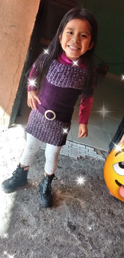 Little girl in purple dress with smiley emoji.