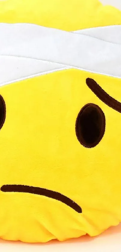 Cute emoji pillow with a bandage design.