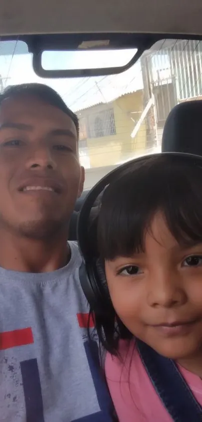 Father and daughter taking a car selfie.