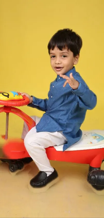 A cheerful child sitting on a colorful toy ride with a vibrant yellow background.