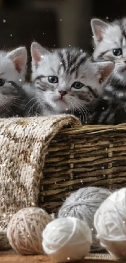 Three kittens in a basket surrounded by yarn balls.