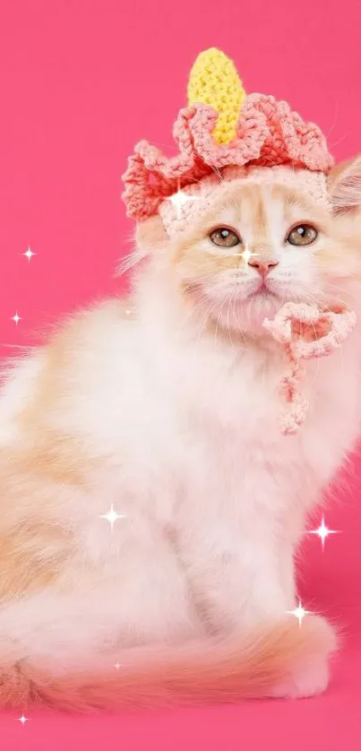 Adorable kitten with a crown against a pink background.