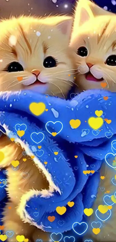 Two cute kittens wrapped in a blue blanket with snowflakes falling around.