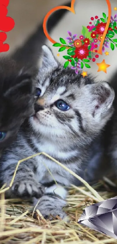 Three cute kittens with colorful floral and heart decorations on hay.