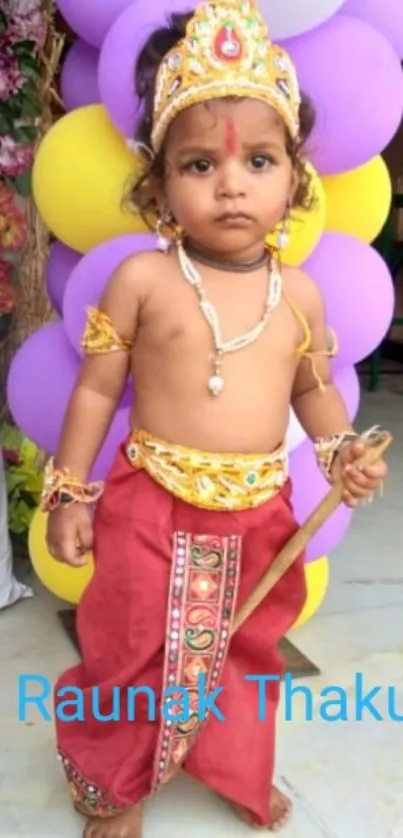 Young child in Krishna costume with balloons.