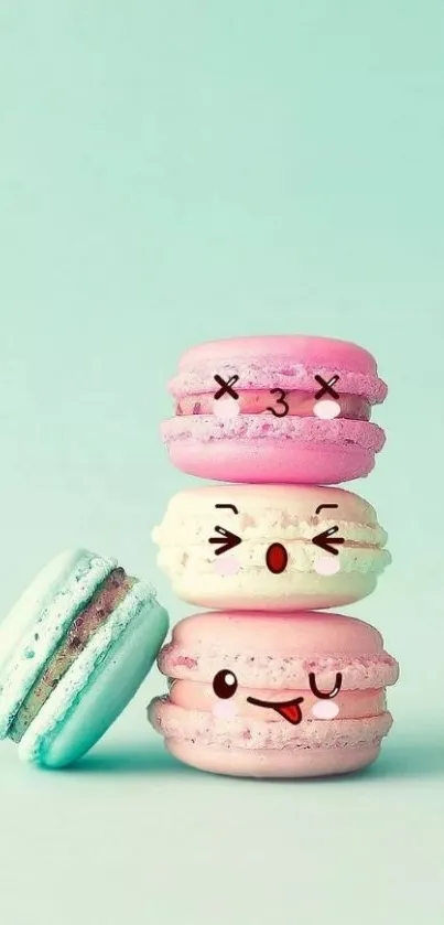 Stack of cute macarons with emoji faces on a mint green background.